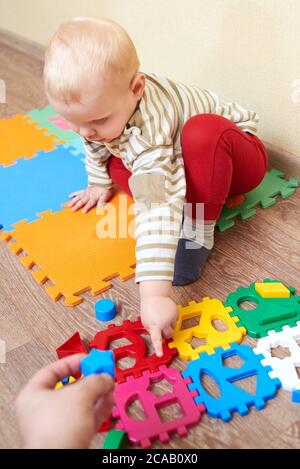 Papa gibt dem Kind eine Figur zum Falten Sortierer Spielzeug, pädagogische Spiele für Kinder. Stockfoto