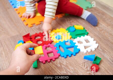 Papa gibt dem Kind eine Figur zum Falten Sortierer Spielzeug, pädagogische Spiele für Kinder. Stockfoto