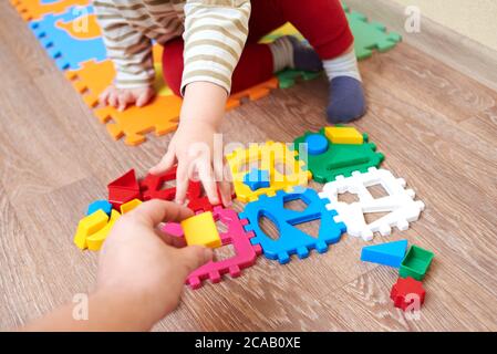 Papa gibt dem Kind eine Figur zum Falten Sortierer Spielzeug, pädagogische Spiele für Kinder. Stockfoto