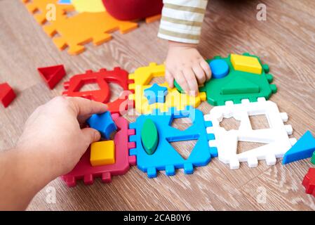 Papa gibt dem Kind eine Figur zum Falten Sortierer Spielzeug, pädagogische Spiele für Kinder. Stockfoto