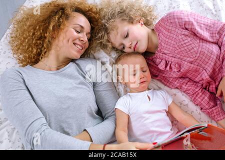 Lesestutte vor der Nacht. Foto von oben. Naughty Baby will nicht auf Märchen Tailes hören Stockfoto