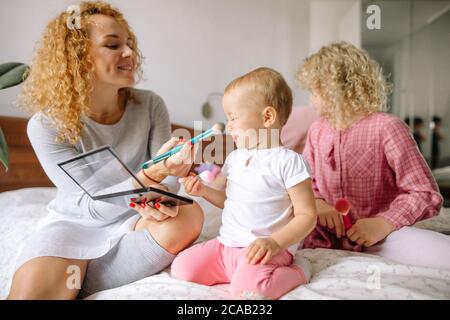 Ehrfürchtige Frau pudert die Nase ihres Babys. Nahaufnahme Foto. Stockfoto