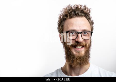 Friseur und Frisur Konzept. Angenehm aussehender Barbier mit Bart auf fröhlich lächelndem Gesicht. Bärtig glücklicher Hipster in Brille lächelt vor der Kamera Stockfoto