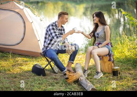 Awesome Mädchen ist Wasser zu ihrem Freund geben, während in der Landschaft ruhen. In voller Länge Porträt. Stockfoto