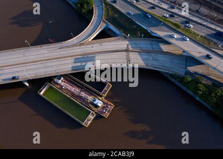 Philadelphia, USA. 6. August 2020: Ein Lastkahn auf dem Schuylkill River, der nach dem tropischen Sturm Isaias während des Hochwassers ungesichert wurde, kollidierte mit einer Brücke und führte zur Schließung der Interstate 676 durch die Innenstadt von Philadelphia, 5. August 2020. Staatliche Transportagentur PennDOT sagte nach der Inspektion, dass die Brücke strukturell solide war, aber die Autobahn würde einen weiteren Tag geschlossen bleiben müssen, bevor die Armee Corps of Engineers, die das Projekt, das die Barge engagiert beaufsichtigt, würde in der Lage sein, es zu bewegen. Kredit: ZUMA Press, Inc./Alamy Live Nachrichten Stockfoto