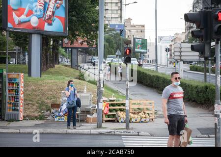 BELGRAD, SERBIEN - 16. JULI 2020: Junge Frau mit einer Atemmaske, die einen Anruf auf ihren Smartphone-Apps in der Straße von Belgrad, du Stockfoto