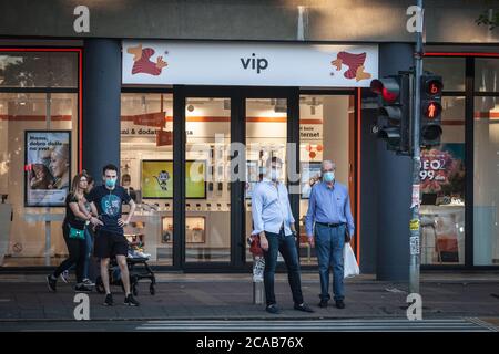 BELGRAD, SERBIEN - 20. JULI 2020: Drei Männer, ein junger und zwei mittlere Alter Blick auf einen Straßenverkehr auf einem Boulevard von Belgrad mit Gesichtsmaske PR Stockfoto