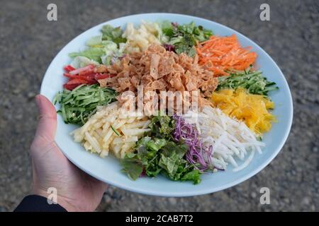 Yee sang, Prosperity Toss ist ein kantonesischer roher Fischsalat, gemischt mit geschreddertem Gemüse und Saucen. Ein berühmtes chinesisches Neujahrsgericht in Malaysia. Stockfoto