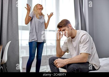 Frau müde, dass ihr Mann ist ein Lappen, blonde Frau drückt Unzufriedenheit zu Hause, unglücklich ungesunde Beziehungen Stockfoto