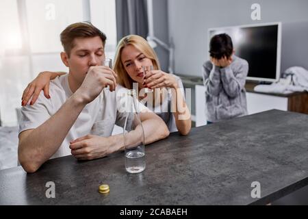 Alkoholiker Eltern kümmern sich nicht um das Kind, kaukasische Familie leiden unter Alkoholabhängigkeit. Verzweifeltes kleines Kind weinen, um Hilfe bitten, braucht etwas lov Stockfoto