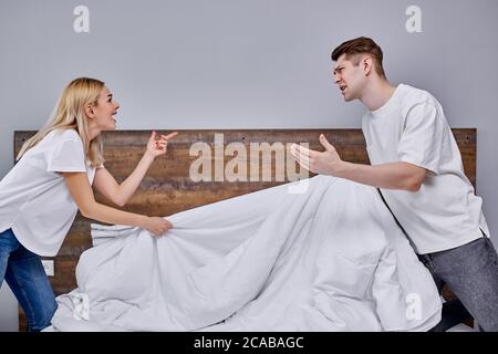 Schöne junge kaukasische verheiratete Paar haben emotionale Streit zu Hause am Morgen, sie haben nicht etwas teilen, ihre Meinungen nicht übereinstimmen Stockfoto
