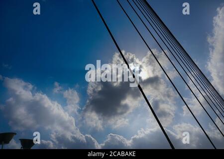 Sonnenstrahlen, die durch Wolken in blauem Himmel über der 2nd Hoogly Bridge, Kalkutta, West Bengal, Indien. Stockfoto