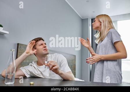 Lassen Sie mich allein Mitglied der Familie leiden unter Alkoholabhängigkeit, kaukasischen verheirateten Paar zu Hause streiten. Alkohol, Familienbeziehungen Stockfoto