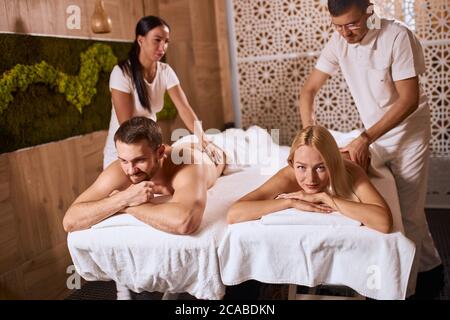 Junge charmante Paar erhalten professionelle Entspannung Handmassage in Wellness Beauty Spa Salon, liegen auf Massageliege, gute Zeit, satisfact Stockfoto