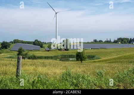 WISCONSIN, USA - Jul 07, 2020: Windkraftanlagen und Sonnenkollektoren für nachhaltige Energie auf einem Bauernhof Stockfoto