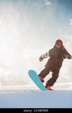 Furchtloser Snowboarder auf einer Piste. Aktiver Athlet macht einen Trick. Sportler mit einem Snowboard, das Tricks ausführt Stockfoto
