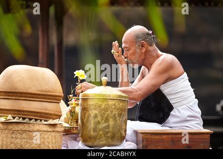 Ein balinesischer Leiter der hinduistischen Zeremonie betet um Wasser Für die Zeremonie verwendet werden Stockfoto