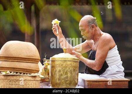 Ein Führer der balinesischen hinduistischen religiösen Zeremonien, die in einer rituellen Zeremonie beten Stockfoto