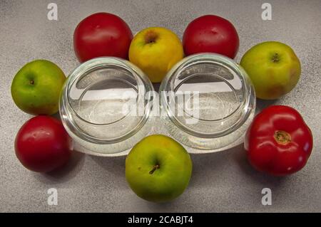 Foto Äpfel grüne und rote Tomaten mit zwei Gläsern auf Grauer Hintergrund Stockfoto
