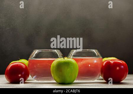 Foto Äpfel grüne und rote Tomaten mit zwei Gläsern auf Gemischter Hintergrund Stockfoto