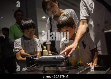 Hiroshima, Japan. August 2019. Eine Familie schaut sich ein Miniaturmodell der Atombombe namens "Little Boy" an, die am 6. August 1945 auf Hiroshima im Friedensdenkmalmuseum von Hiroshima abgeworfen wurde.das Friedensdenkmalmuseum von Hiroshima befindet sich im Friedensdenkmalpark von Hiroshima und wurde 1955 gegründet. 10 Jahre nach dem Atombombenanschlag in Hiroshima und Nagasaki. Kredit: Guillaume Payen/SOPA Images/ZUMA Wire/Alamy Live Nachrichten Stockfoto