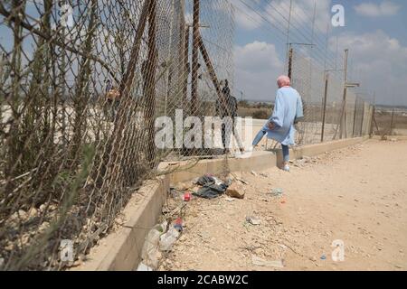 5. August 2020: Westjordanland, Palästina. 05. August 2020. Palästinenser durchschneiden eine Lücke im israelischen Sicherheitszaun in der Nähe des Dorfes Far'un im Gouvernement Tulkarem im Westjordanland. Die israelische Trennmauer wurde von Israel als Sicherheitsbarriere gerechtfertigt, aber sie wurde nicht direkt entlang der Grünen Linie errichtet, die das Westjordanland von Israel trennt, da sie das Westjordanland für 85% seiner Route durchschneidet. Das bedeutet, dass Israel durch die Barriere mehr als 9% des Westjordanlandes annektiert hat, zahlreiche palästinensische Dörfer und getrennte Gemeinschaften geteilt und 25,000 Palästinenser isoliert hat. Der Stockfoto