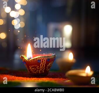 Happy Diwali, beleuchtete Diya-Lampe auf der Straße in der Nacht mit geringer Schärfentiefe Hintergrund Stockfoto