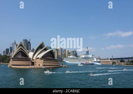 Blick auf das Opernhaus von Sydney, mit der Skyline von Sydney und dem Kreuzfahrtschiff Ovation of the Seas im Hintergrund, Sydney, Australien Stockfoto