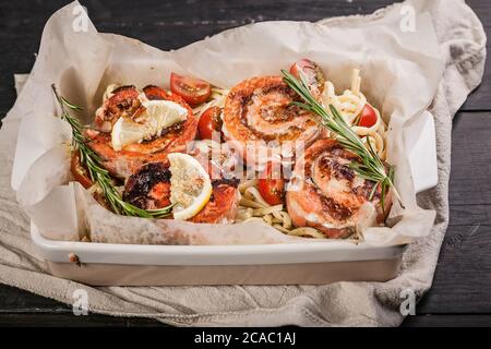 Gebackene Lachsbrötchen mit Frischkäse und Garnelenfleisch, Sauce Ricotta Pesto mit Zitrone. Köstliche Meeresfrüchte-Restaurant Gerichte. Mediterrane Küche Stockfoto