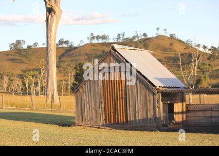 Großes Hühnerstall im Landhausstil auf dem Farmland bei Sonnenuntergang Stockfoto