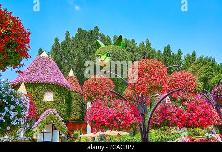 DUBAI, VAE - 5. MÄRZ 2020: Die hängenden Töpfe mit hellen Petunia-Blumen vor der Installation von riesigen Katze und Haus, mit Wohnplan bedeckt Stockfoto