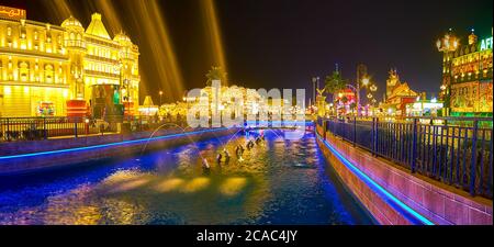 DUBAI, VAE - 5. MÄRZ 2020: Genießen Sie die Brunnen am Kanal des Global Village in den Abendlichtern, am 5. März in Dubai Stockfoto