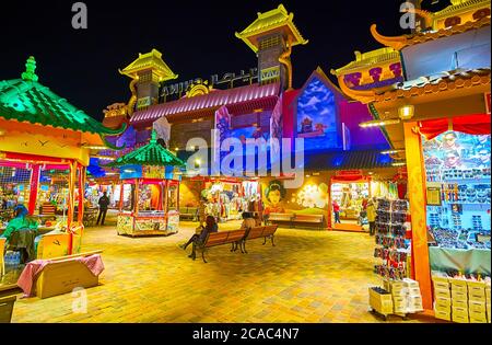 DUBAI, VAE - 5. MÄRZ 2020: Der Hof von China Pavillon des Global Village Dubai mit kleinen Ständen, bietet verschiedene Waren und riesige Tor des Pavillons Stockfoto