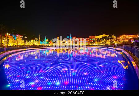 DUBAI, VAE - 5. MÄRZ 2020: Sehen Sie sich die Lichtshow auf Unterwasser-LED-Bildschirm im Teich des Global Village Dubai an, gesäumt mit Pavillons verschiedener Länder Stockfoto