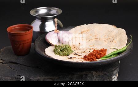 Chutney mit grünem Chili - Thecha und Knoblauch/Lasun Chutney. Serviert mit Jowar Mehl Fladenbrot als bhakar / bhakri bekannt.serviert auf irdenen Teller. Stockfoto