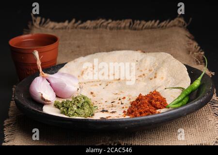 Chutney mit grünem Chili - Thecha und Knoblauch/Lasun Chutney. Serviert mit Jowar Mehl Fladenbrot als bhakar / bhakri bekannt.serviert auf irdenen Teller. Stockfoto