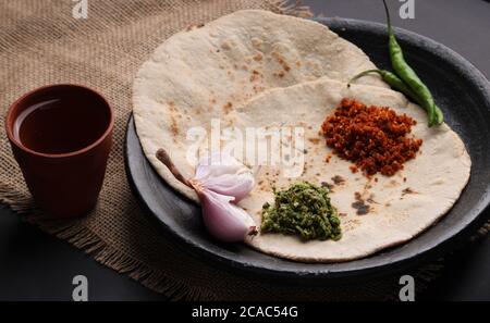 Chutney mit grünem Chili - Thecha und Knoblauch/Lasun Chutney. Serviert mit Jowar Mehl Fladenbrot als bhakar / bhakri bekannt.serviert auf irdenen Teller. Stockfoto