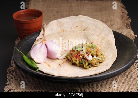 Baigan/Baingan Bharta - Pürierte geröstete Aubergine mit Gewürzen und Gemüse gekocht. Serviert mit Jowar Mehl Fladenbrot als bhakar / bhakri bekannt. Stockfoto