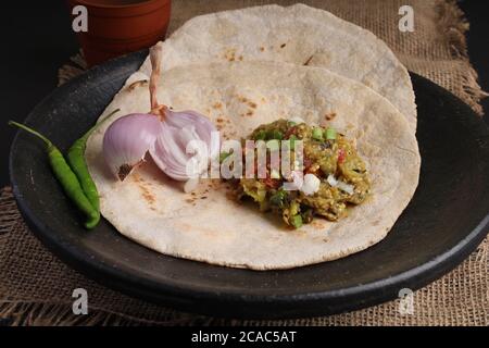 Baigan/Baingan Bharta - Pürierte geröstete Aubergine mit Gewürzen und Gemüse gekocht. Serviert mit Jowar Mehl Fladenbrot als bhakar / bhakri bekannt. Stockfoto