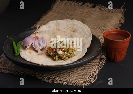 Baigan/Baingan Bharta - Pürierte geröstete Aubergine mit Gewürzen und Gemüse gekocht. Serviert mit Jowar Mehl Fladenbrot als bhakar / bhakri bekannt. Stockfoto