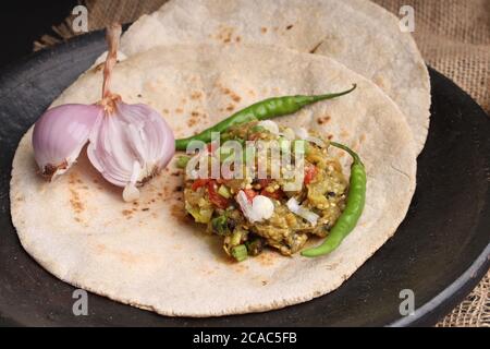 Baigan/Baingan Bharta - Pürierte geröstete Aubergine mit Gewürzen und Gemüse gekocht. Serviert mit Jowar Mehl Fladenbrot als bhakar / bhakri bekannt. Stockfoto