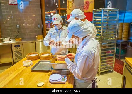 DUBAI, VAE - 3. MÄRZ 2020: Die Köche wickeln orientalische Baozi Knödel in der offenen Küche des Oriental Restaurant in Dubai Mall, am 3. März in Dubai Stockfoto