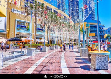 DUBAI, VAE - 3. MÄRZ 2020: Der angenehme Spaziergang entlang der Promenade, die zwischen Dubai Mall und Burj Lake führt und genießen Sie moderne arabische Erholung ar Stockfoto
