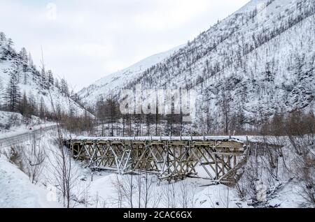 Holzbrücke, verschneite Berge, Gulag, Kolyma, die R504 Kolyma Autobahn, die Straße der Knochen, Jakutien, Sacha Republik, Russischer Norden, Pole der Kälte Stockfoto