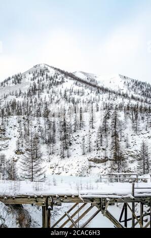 Holzbrücke, verschneite Berge, Gulag, Kolyma, die R504 Kolyma Autobahn, die Straße der Knochen, Jakutien, Sacha Republik, Russischer Norden, Pole der Kälte Stockfoto