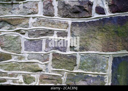 Pennsylvania Bauernhaus Steinmauer Hintergrund. Lebendige lila, blau und grün Feldstein, Mauerwerk Textur, solide robust und zuverlässig. Stockfoto