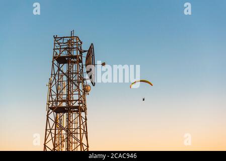 Telekommunikation Mast und fliegende Gleitschirm über Menorca Insel, Spanien Stockfoto