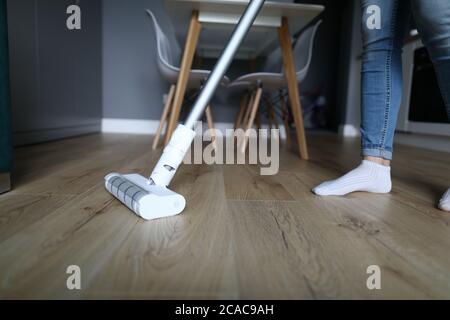 Die Frau in der Wohnung wäscht den Boden mit Mopp Stockfoto