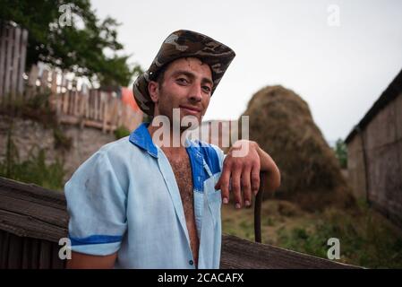 Alaverdi / Armenien - 20. Juli 2019: Porträt eines attraktiven armenischen jungen Mannes, der in der Landwirtschaft mit einer Gabel arbeitet Stockfoto