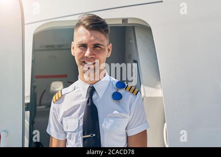 Attraktiver junger Flieger, der die Kamera anschaut Stockfoto